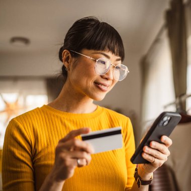 Japon olgun kadın internet üzerinden cep telefonu ve kredi kartıyla satın alıyor.