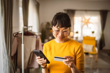 Japon olgun kadın internet üzerinden cep telefonu ve kredi kartıyla satın alıyor.