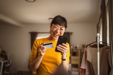 Japon olgun kadın internet üzerinden cep telefonu ve kredi kartıyla satın alıyor.