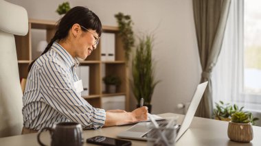 Olgun Japon kadın, belgeyi tut ve ofisinde onun hakkında yaz.