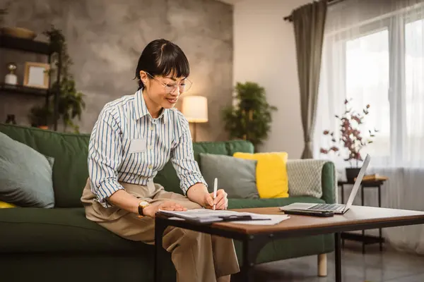 Ώριμη Γιαπωνέζα Γυναίκα Γυαλιά Εργασίας Από Σπίτι Και Υπογράψει Έγγραφο Εικόνα Αρχείου