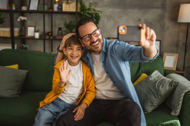 Baba ve oğul oturma odasında kendi portresini yapıyorlar, mutlu, birlikte.