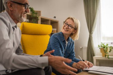 Olgun yaşlı kadın sigorta, sözleşme ya da faturayı evde imzalar.