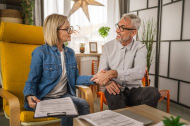 Olgun karı ve koca, evlerinde imza üstüne el sıkışırlar.