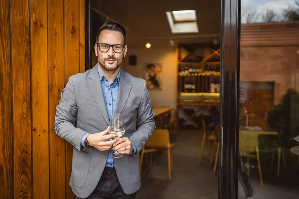 stock image Portrait of adult man sommelier stand in front of winery and hold wine