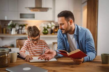 Babanın kitap yardımı ve oğlunun ödevlerine yardım etmesi.