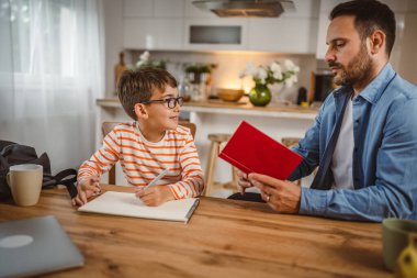 Babanın kitap yardımı ve oğlunun ödevlerine yardım etmesi.