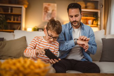 Baba saatine bak oğlum. Cep telefonundan video oyununu bitirmek için bekle.