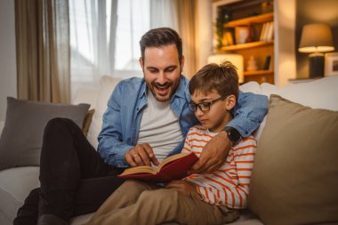 Baba ve oğlu Kafkasyalı bir kitap okuyor ve evde birlikte vakit geçirirken eğleniyorlar.