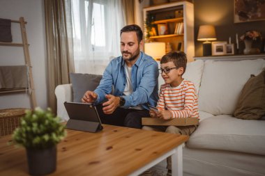Babası kredi kartını elinde tutarken oğlu paketi elinde tutarken internetten tablet almış.