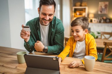 Baba ve oğlu Kafkasyalı online alışveriş yapıyor. Evdeki kredi kartıyla.