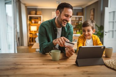 Baba ve oğlu Kafkasyalı online alışveriş yapıyor. Evdeki kredi kartıyla.