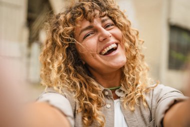 Yetişkin bir kadın cep telefonunu tutar ve kendi portresini çeker.