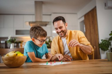 Baba ve oğul masa oyunu oynuyorlar. Evde iyi eğlenceler.