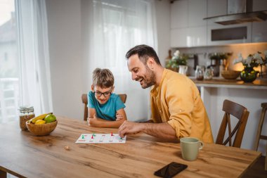 Baba ve oğul masa oyunu oynuyorlar. Evde iyi eğlenceler.