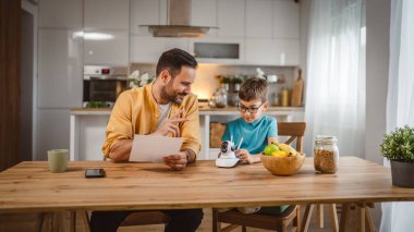Baba ve oğlu beyaz tenli ev mutfağına bağlanıyor ve güvenlik kamerası yerleştiriliyor.