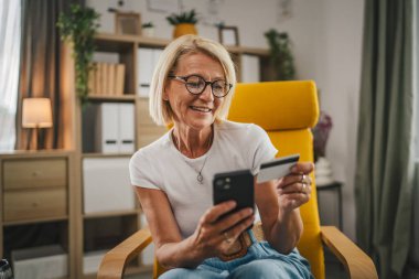 Yetişkin bir son sınıf öğrencisi kredi kartıyla ve cep telefonuyla internetten satın alır.