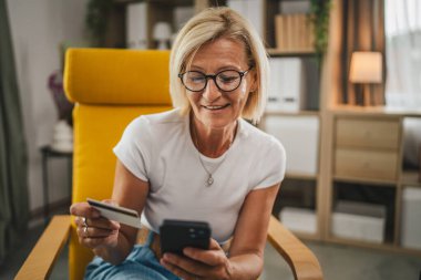 Yetişkin bir son sınıf öğrencisi kredi kartıyla ve cep telefonuyla internetten satın alır.