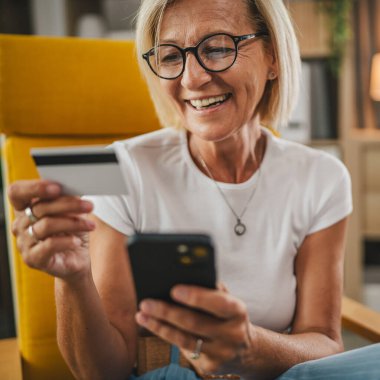 Yetişkin bir son sınıf öğrencisi kredi kartıyla ve cep telefonuyla internetten satın alır.