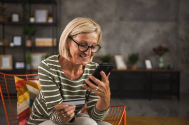 Yetişkin bir son sınıf öğrencisi kredi kartıyla ve cep telefonuyla internetten satın alır.