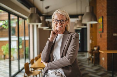 Çalışan yetişkin bir kadının portresi ve şaraphanede gülümsemesi.