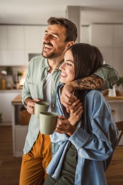 Erkek arkadaşı ve kız arkadaşı mutfaktaki ilk sabah kahvelerinin tadını çıkarıyorlar.