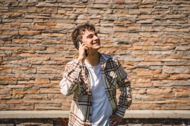 Kafkasyalı bir gencin portresi cep telefonuyla konuşuyor.