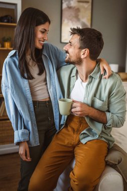 Erkek arkadaş ve kız arkadaş karı koca kahve içip evde eğleniyorlar.