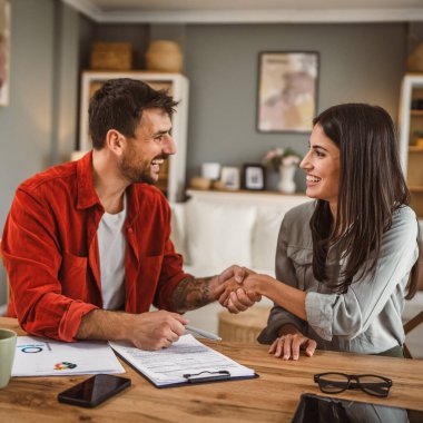 Kadın mali danışman erkeğin müşterisiyle tokalaşıyor