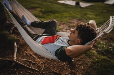 Genç çocuk, dağda bir fincan kahveyle hamakta uzanıyordu.