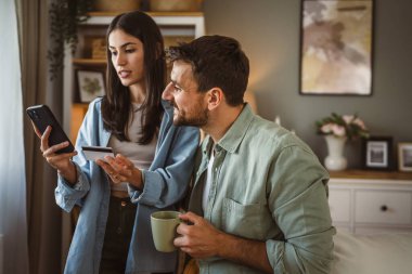 Erkek arkadaş koca ve kız arkadaş eşi cep telefonuyla evde kredi kartıyla satın alıyorlar.