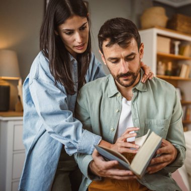 Sevgili koca kitap okurken sevgili eş ona sarılır aşk, mutluluk