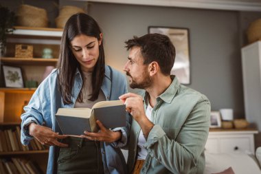 Kız arkadaşı ve erkek arkadaşı oturma odasında birlikte bir kitap okudu.