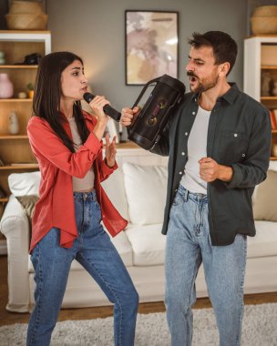 Kadın mikrofonu tut ve şarkı söyle, erkek hoparlörü tut karaoke partisi