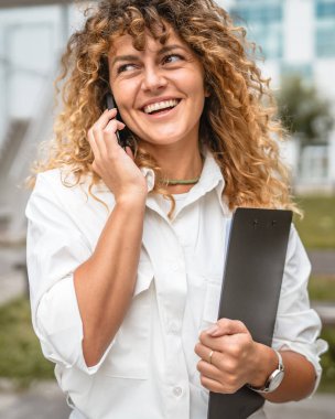 İş kadını panoyu bekletin ve cep telefonuyla arayın.