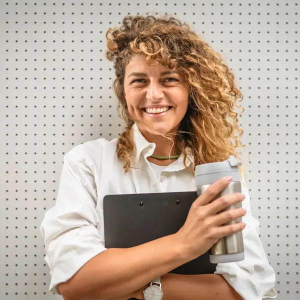 stock image Adult business woman stand in front business building hold clipboard and thermos cup take a break from work