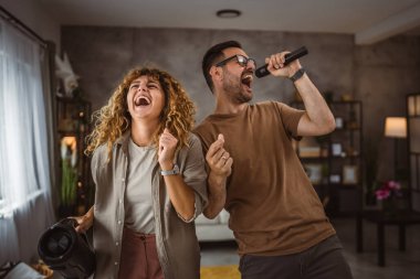 Sevgilisi mikrofonda şarkı söylerken kız arkadaşı karaoke yapıyor.