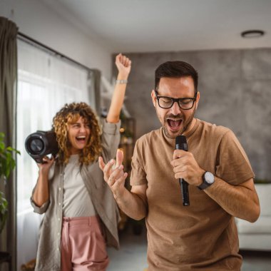 Sevgilisi mikrofonda şarkı söylerken kız arkadaşı karaoke yapıyor.