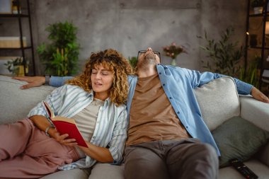 Kız arkadaşım evdeki kanepede kitap okudu.