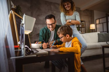 Üç kişilik mutlu bir aile, ödevlerini evde bir defterde yapıyor.