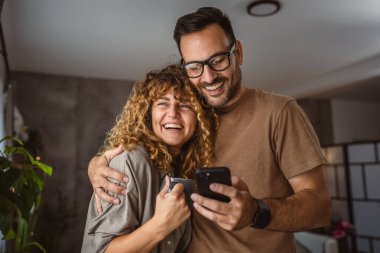 Yetişkin çift portresi. Karı koca cep telefonu kullanıyor.