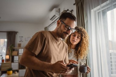 Koca, karısı ona katılmaya çalışırken tek başına cep telefonu kullanmak istiyor.