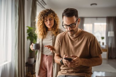 Koca, karısı ona katılmaya çalışırken tek başına cep telefonu kullanmak istiyor.