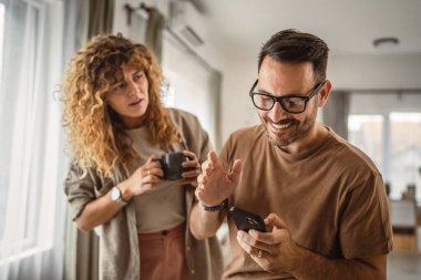 Koca, karısı ona katılmaya çalışırken tek başına cep telefonu kullanmak istiyor.