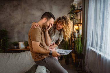 Kadın, bebeğinin ultrason fotoğrafına bakarken kocasına sarılır.