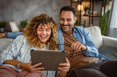 Yetişkin çiftler evde tablet kullanır. Birlikte iyi eğlenceler.