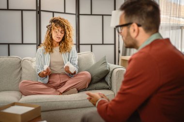 Psikoterapist ağlayan kadın müşteriyi dinler ve panoya yazar.