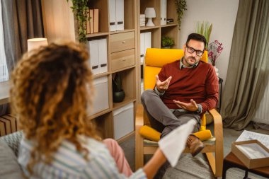 Psikoterapist kadın müşteriyi gözlemler ve sorunu hakkında düşünür.