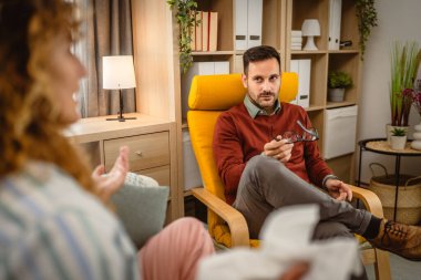 Psikoterapist kadın müşteriyi dinler ve ona destek ve tavsiye verir.