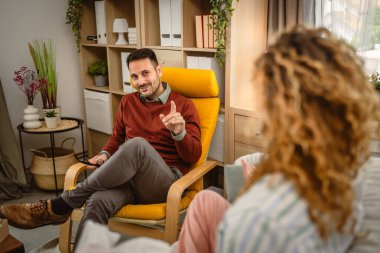 Psikoterapist kadın müşteriyi dinler ve ona destek ve tavsiye verir.